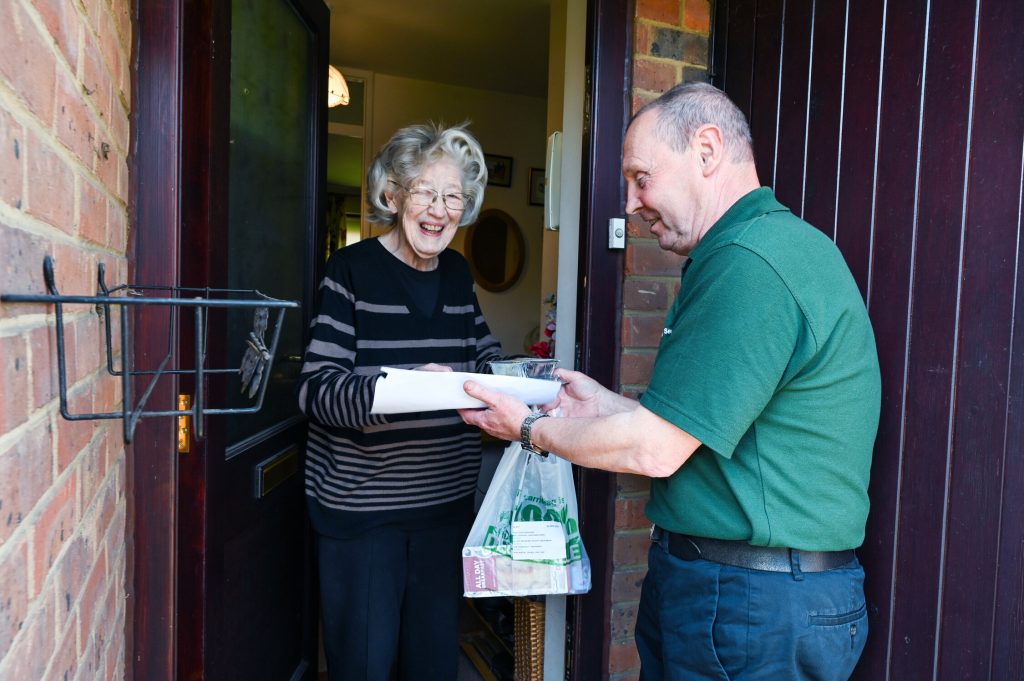 An older lady receiving goods from delivery service.